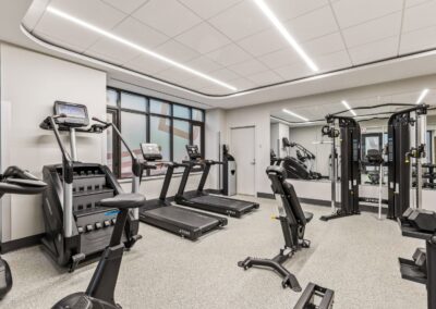 View of fitness space with cardio machines, free weights, and other equipment with a dedicated space for stretching or dance.