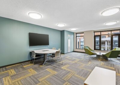 View of tech-equipped group study room with open workspaces and smart TV.