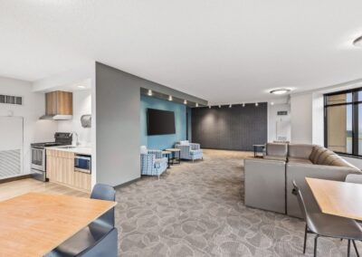 View of social lounge kitchen with oven, microwave, large sink, and plenty of space to gather.